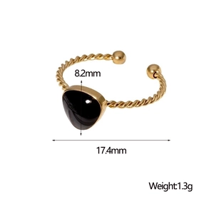 Detail shot of a gold twisted ring with a black heart stone and size measurements