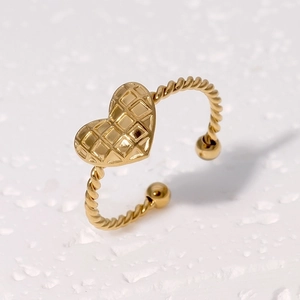 Detail of gold heart ring featuring quilted texture and twisted adjustable band design