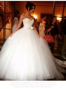 Détail d'une robe de mariée à paillettes avec taille ajustée et grand nœud blanc