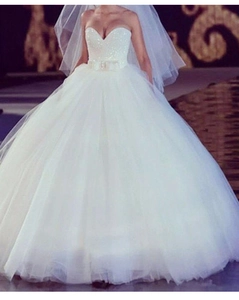 Détail d'une robe de bal blanche à paillettes avec décolleté en cœur et jupe en tulle