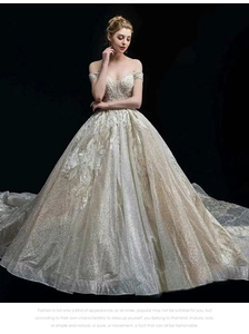 Close-up of off-shoulder wedding gown featuring sequins and intricate lace embroidery