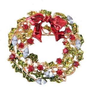 Detail of Christmas wreath brooch with red bow and sparkling rhinestones on gold alloy