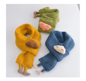 Close-up of soft knitted baby scarves in green, yellow and blue with cute cloud charms