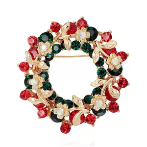 Detailed view of Christmas wreath brooch with red and green crystals in gold setting