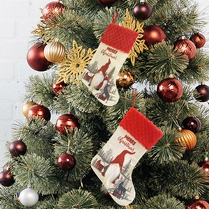 Detail of Grinch themed Christmas stockings hanging on a festive tree with gold ornaments