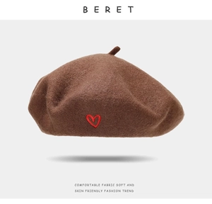 Detail of red heart embroidery on the coffee brown wool beret with soft texture