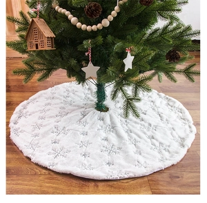 Detail of white plush Christmas tree skirt with silver sequin embroidered snowflakes
