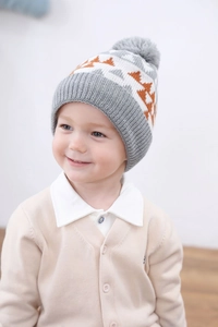 Close-up of knit toddler hat showing gray pom-pom and zigzag pattern textures