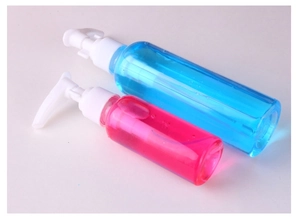 Macro detail of portable clear PET pump bottles with blue and pink liquid on white