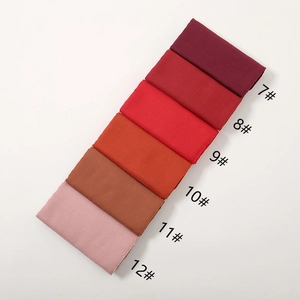 Detail view of neatly folded cotton linen scarves in warm gradient color palette