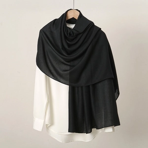 Detail view of high-quality black linen scarf fabric draped as a soft, elegant shawl