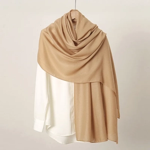 Detail of light brown linen scarf draped over a white shirt showing texture and drape