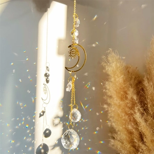 Detail of sun and moon crystal suncatcher casting rainbow light on the wall