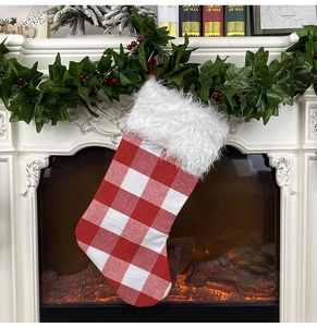 Detailed view of red white buffalo check Christmas stocking hung on a cozy fireplace mantle