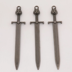 Close-up of three antique silver sword charms with cat head design for DIY jewelry making