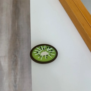 Detailed close-up of a kiwi-shaped acetate hair clip with green pulp and black seeds