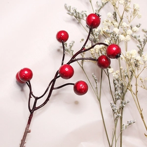 Close-up of artificial red berries with realistic branch texture for Christmas decoration