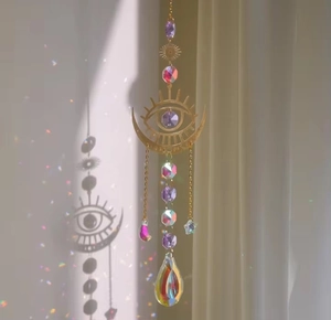 Detail showing crystal moon suncatcher creating rainbow light spots on wall
