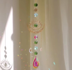 Macro detail of sun catcher prism reflecting rainbow light with evil eye metal charm