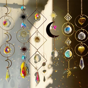 Crystal suncatcher hanging with moon star shapes reflecting rainbows on a wall