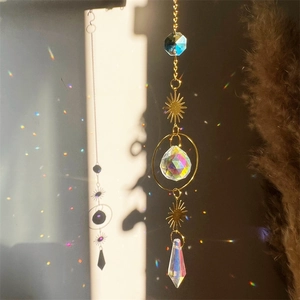 Golden crystal suncatcher with moon and star prisms reflecting colorful sunlight