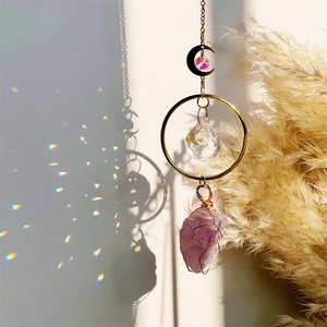 Natural amethyst suncatcher with gold moon and crystal prism casting rainbow light