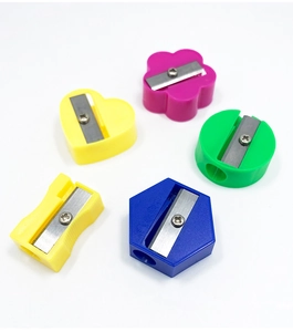 Macro detail of colorful mini plastic sharpeners in heart, flower, and geometric shapes