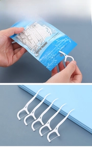Detail showing dental floss picks being removed from a blue resealable storage pouch