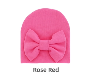 Detail view of the rose red baby knit hat featuring a large decorative cotton bow