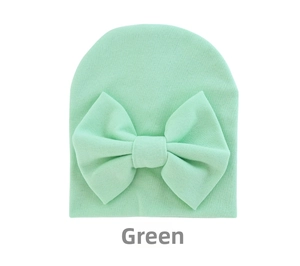 Close-up of soft mint green knitted baby hat with large bow detail for newborns