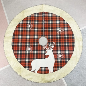 Red and black plaid Christmas tree skirt featuring a white reindeer and snowflake design