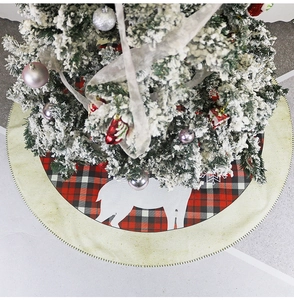 Close-up of red plaid Christmas tree skirt with reindeer silhouettes and linen border