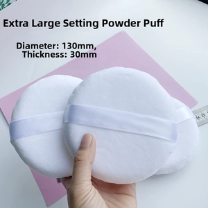 Macro shot of a 130mm extra-large powder puff with white ribbon and thickness measurement