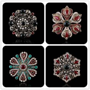 Vintage Baroque brooches set with colorful rhinestones in an antique gold finish