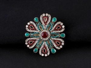 Close-up of Baroque style vintage gold brooch with colorful rhinestones on black fabric