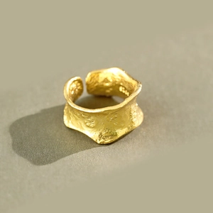 Macro shot of irregular molten texture and gold hammered finish on the geometric ring