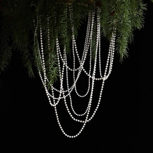 White beaded pearl garland for Christmas tree decoration on dark pine background