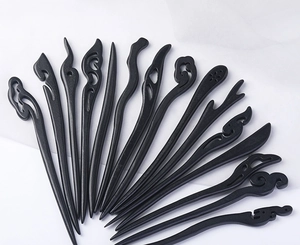 Macro shot of 13 black ebony-style wooden hairpins with various intricate carved designs
