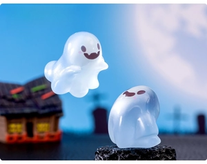Luminous Halloween ghost figurines glowing in blue and white on decorative black base