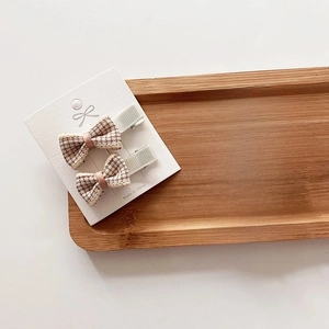 Set of 4 cute plaid bow hair clips for girls in earthy tones on wooden display
