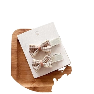 Set of two plaid bow hair clips for girls featuring pink ribbon and green fabric wrap