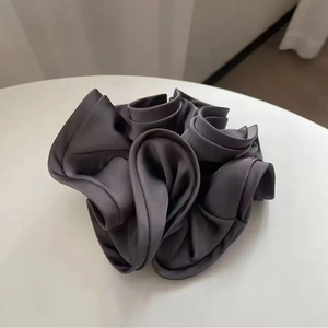 Close-up of dark grey silk satin scrunchie showing smooth texture and ruffled details
