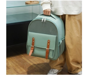 Green pet carrier backpack with breathable mesh and brown leather strap detail