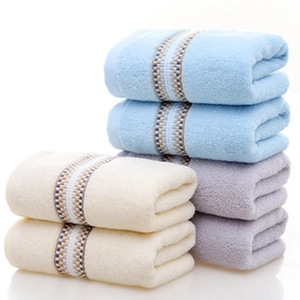 Detail of stacked cotton towels showing water-ripple texture and jacquard border details