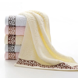 Close-up of thick cotton towels with wave texture and floral embroidery detail