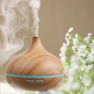 Detail view of mist rising from a wood grain essential oil diffuser with LED light bar