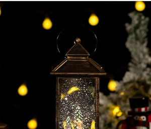 Close-up of vintage bronze Christmas lantern featuring a snowy forest scene and warm LED