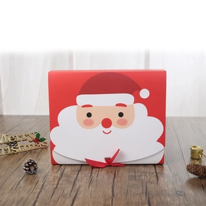 Red Santa Claus Christmas paper gift box with ribbon on wooden table background