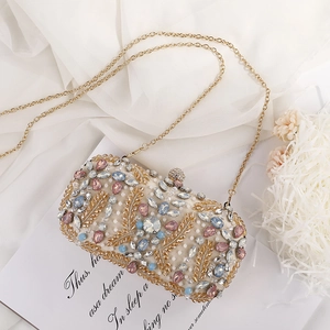 Golden clutch bag with colorful crystals and leaf sequins shown with a chain strap