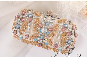 Detailed close-up of a luxury clutch with gold leaf beading and colorful rhinestones